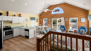 Uma cozinha espaçosa com eletrodomésticos modernos, uma sala de jantar com teto de madeira e um espaço de estar aconchegante com vista para o exterior.