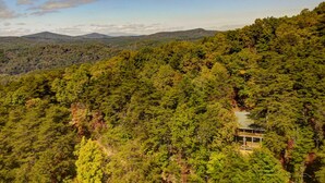 A forested mountain area with a cabin.