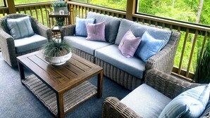 A covered outdoor seating area with wicker furniture, a wooden table, and a potted plant. - Cozy Cottage minutes from Wineries & 5 miles to Dahlonega Square (Dahlonega)