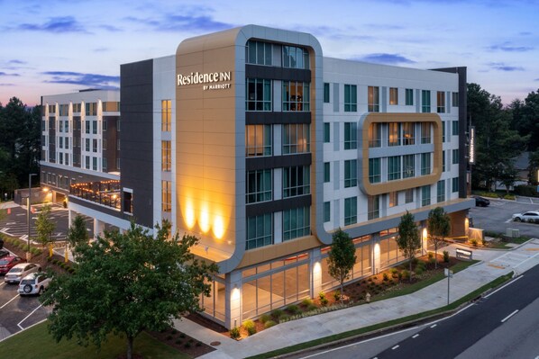 Situated on a corner lot, this hotel features a striking facade with large windows and a prominent entrance.