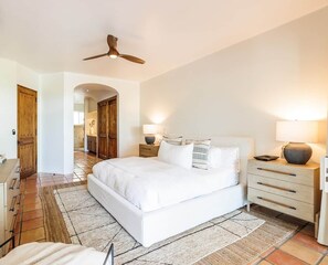 A bedroom with a bed, bedside tables, a ceiling fan, and a rug. - Peaceful Palmilla Ocean View Oasis Steps to Beach (Palmilla)