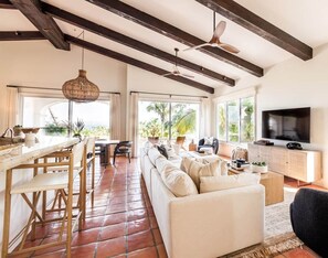 A spacious living area with a sofa, TV, and dining setup. - Peaceful Palmilla Ocean View Oasis Steps to Beach (Palmilla)
