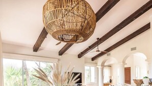 A modern dining area with a large table, black chairs, and a woven light fixture. - Peaceful Palmilla Ocean View Oasis Steps to Beach (Palmilla)