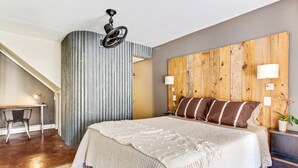 A bedroom with a large bed, a desk, a chair, a wooden headboard, and a ceiling fan. - Charming One Bedroom Walkable to Zilker & South Lamar; Secluded multi-unit home (Austin)