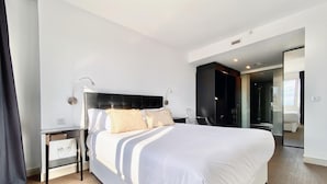 A modern hotel room with a large bed, a bedside table, a mirror, and a walk-in closet. - Charming Eurobuilding Skyline Madrid - Spectacular Views (Madrid)