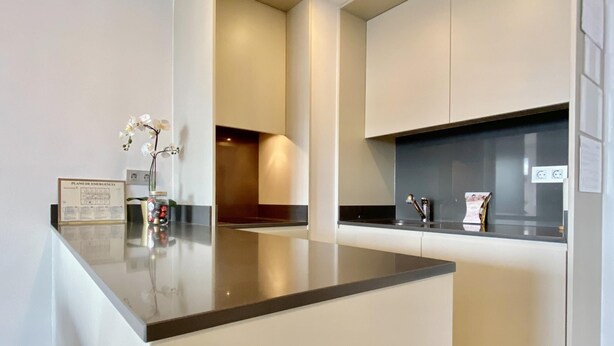 A modern kitchen with a central island, white cabinetry, and a small decorative plant. - Charming Eurobuilding Skyline Madrid - Spectacular Views (Madrid)