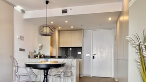 A modern kitchen with a dining area featuring a round table and clear chairs. - Charming Eurobuilding Skyline Madrid - Spectacular Views (Madrid)