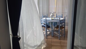 A dining area with a table covered by a blue tablecloth, surrounded by blue chairs, and a white lantern on the table. - Apartment "La Veranda": the beaches of San Lorenzo al Mare just a few steps away (San Lorenzo al Mare)