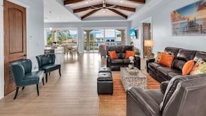 A spacious living room with a high ceiling, a dining area, and a view of the outdoors. - Elev • 5BR/8BA • Game Room • 75’ Deep Canal Dock • Ice Maker • Kayaks • Bikes (Key Colony Beach)