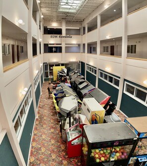 Experience the hotel's spacious atrium, featuring a dining area with tables and chairs, and air conditioning units for a comfortable stay.