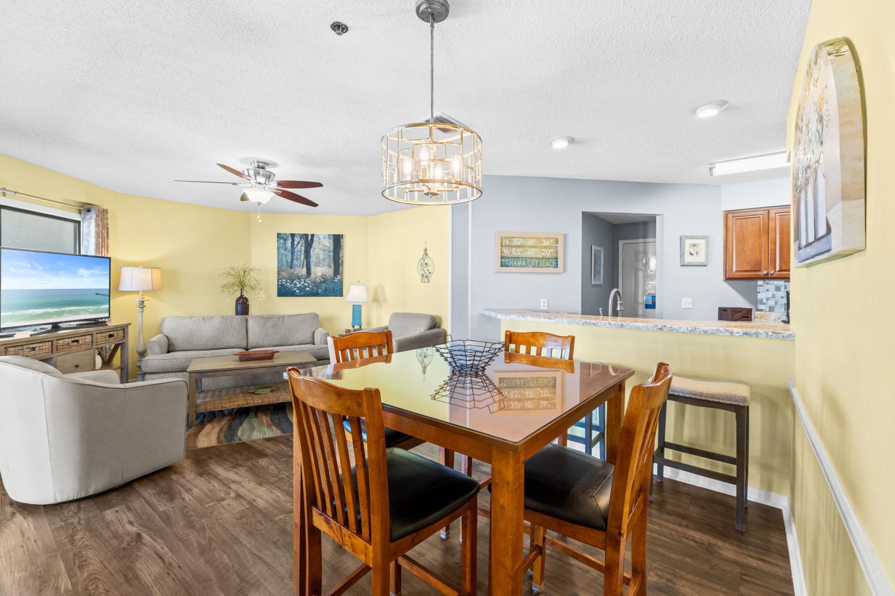A modern living room with a dining table, chairs, a sofa, and a TV.