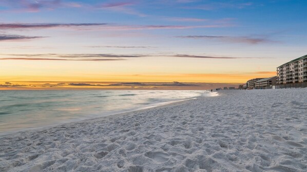A beach with a hotel on the right.