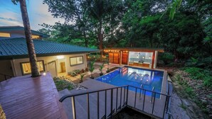 Une maison moderne dotée d’une piscine, entourée d’une végétation luxuriante.