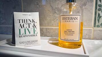 A bottle of Esteban Paris Savon Gel Liquide Hand & Body Cleanser and a sign with the text "Think, Act & Live Responsible".