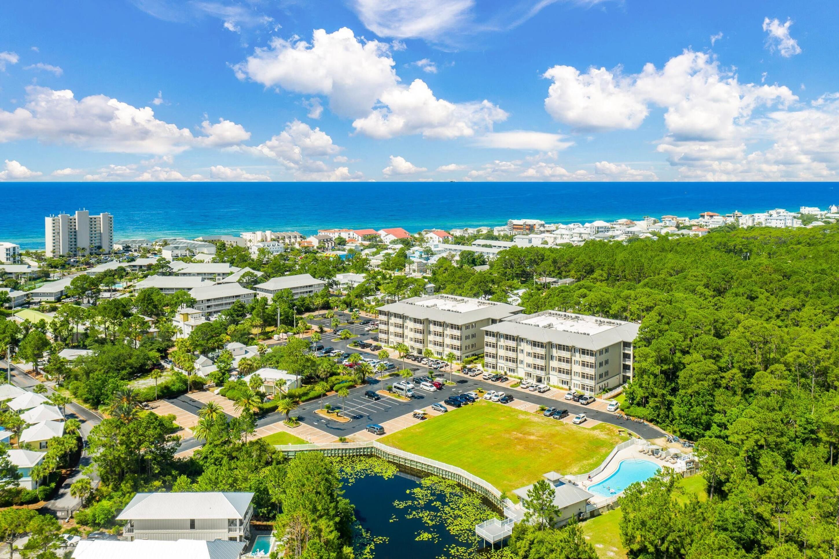 A coastal resort with a large building, a swimming pool, and a view of the ocean.