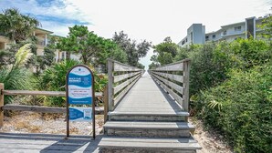 A wooden boardwalk leading to a beach, with a sign indicating beach flag warnings and emergency contact information. - Seagrove Highlands By Panhandle Getaways (Santa Rosa Beach)
