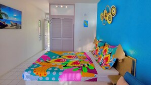 Ein Schlafzimmer mit einem Bett, einer blauen Wand, einer Tür und einem Gemälde.