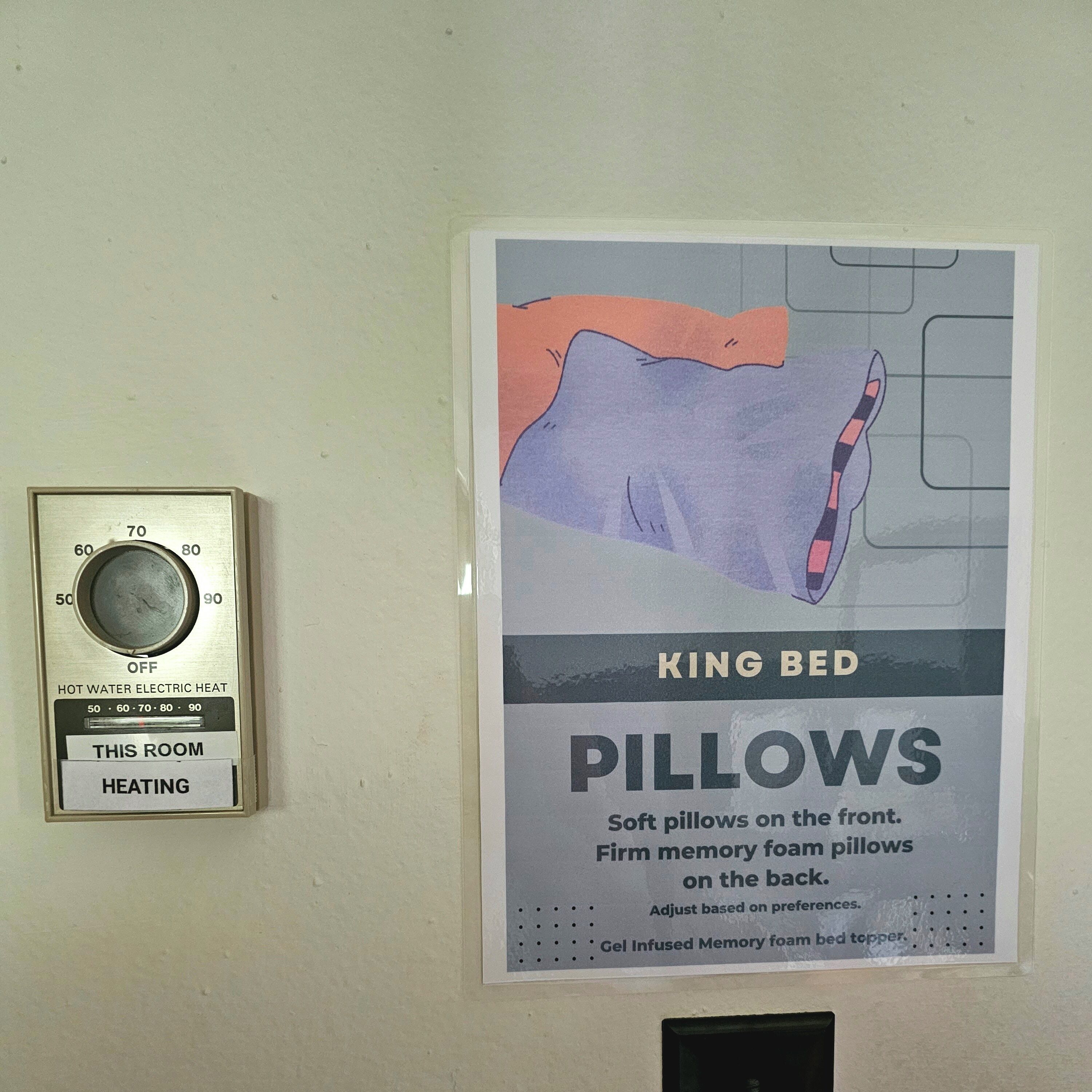 A thermostat and a poster advertising King Bed pillows.