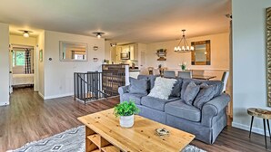 A modern living room with a grey sofa, wooden coffee table, and a staircase leading to another level. - Vernon Condo w/ Deck, Near Appalachian Trail! (Vernon Township)