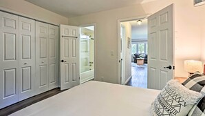 A bedroom with a large bed, white walls, and a view of a balcony. - Vernon Condo w/ Deck, Near Appalachian Trail! (Vernon Township)