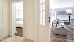 Moderni hotellihuone, jossa on suuri ikkuna, sänky, sohva ja ruokailutila.