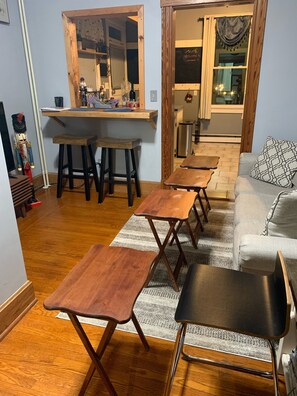 Una sala de estar acogedora con una mesa de centro de madera, un sofá y un comedor con una mesa y sillas de madera.
