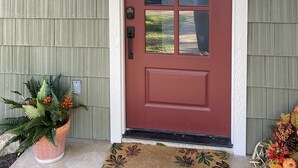 A red door with a glass panel, a welcome mat, and a potted plant. - Newly Renovated Ranch House with  Open Concept (Fredericksburg)