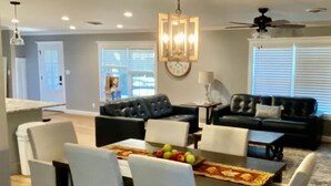 A dining area with a rectangular table, six chairs, and a chandelier. - Newly Renovated Ranch House with  Open Concept (Fredericksburg)