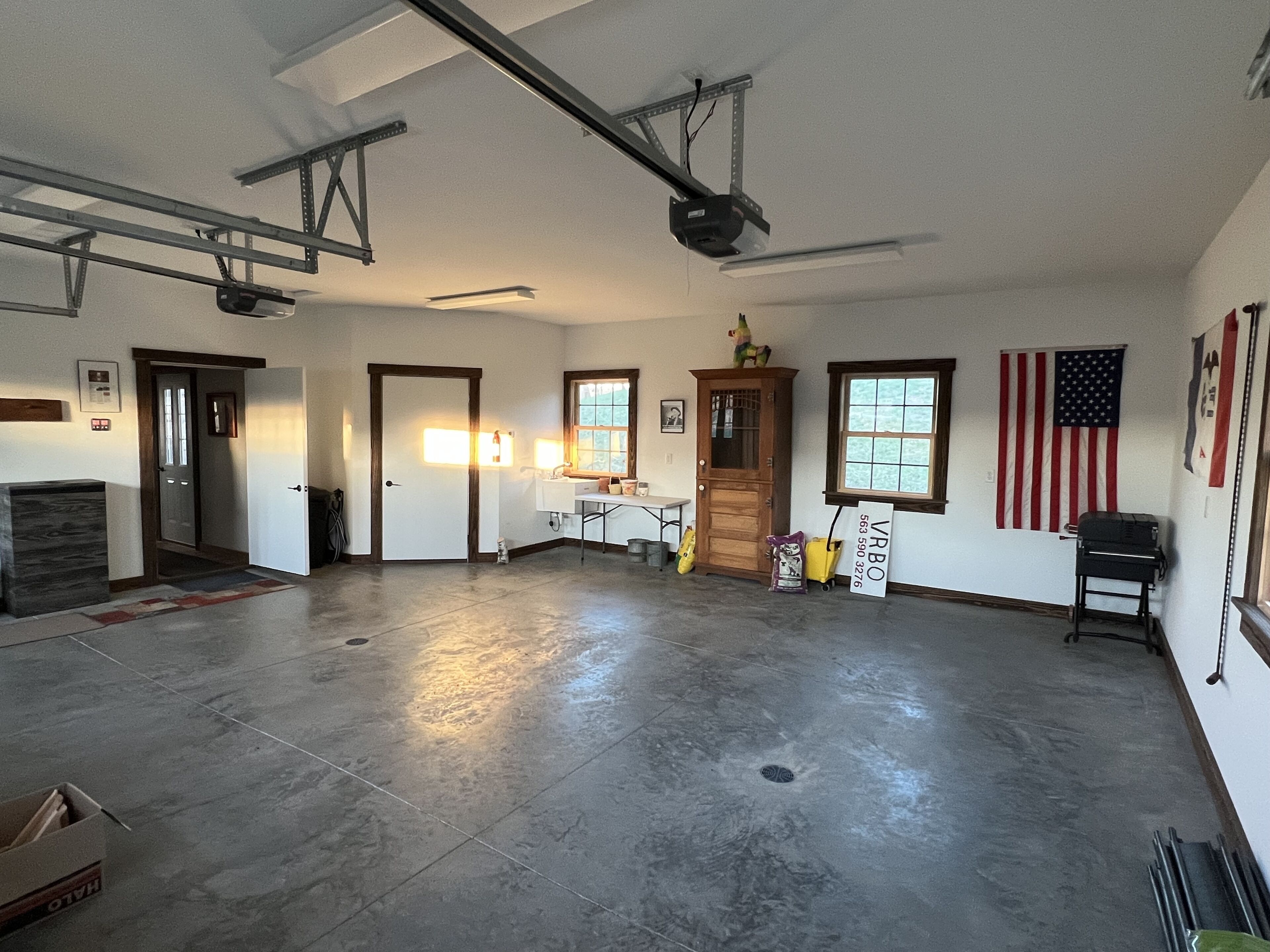 A spacious room with a high ceiling, a large window, and a door.