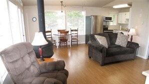Ein Wohnzimmer mit Sofa, Stuhl, Lampe und Esstisch.