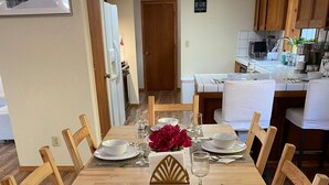 A dining area with a long wooden table set for six, surrounded by wooden chairs. - Enchanting View, Sequoia/Kings Canyon PKs Getaway (Miramonte)