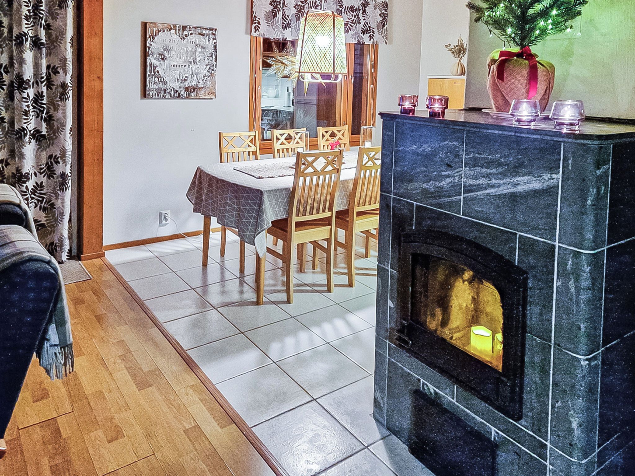 A living room with a fireplace, wooden dining table, and chairs.