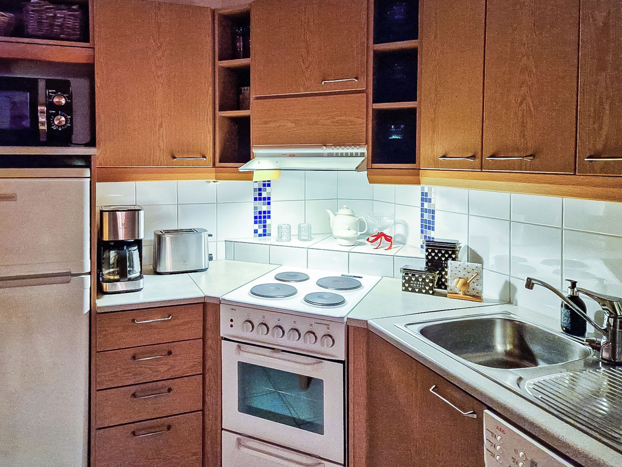 A compact kitchen with a stove, sink, and cabinets.