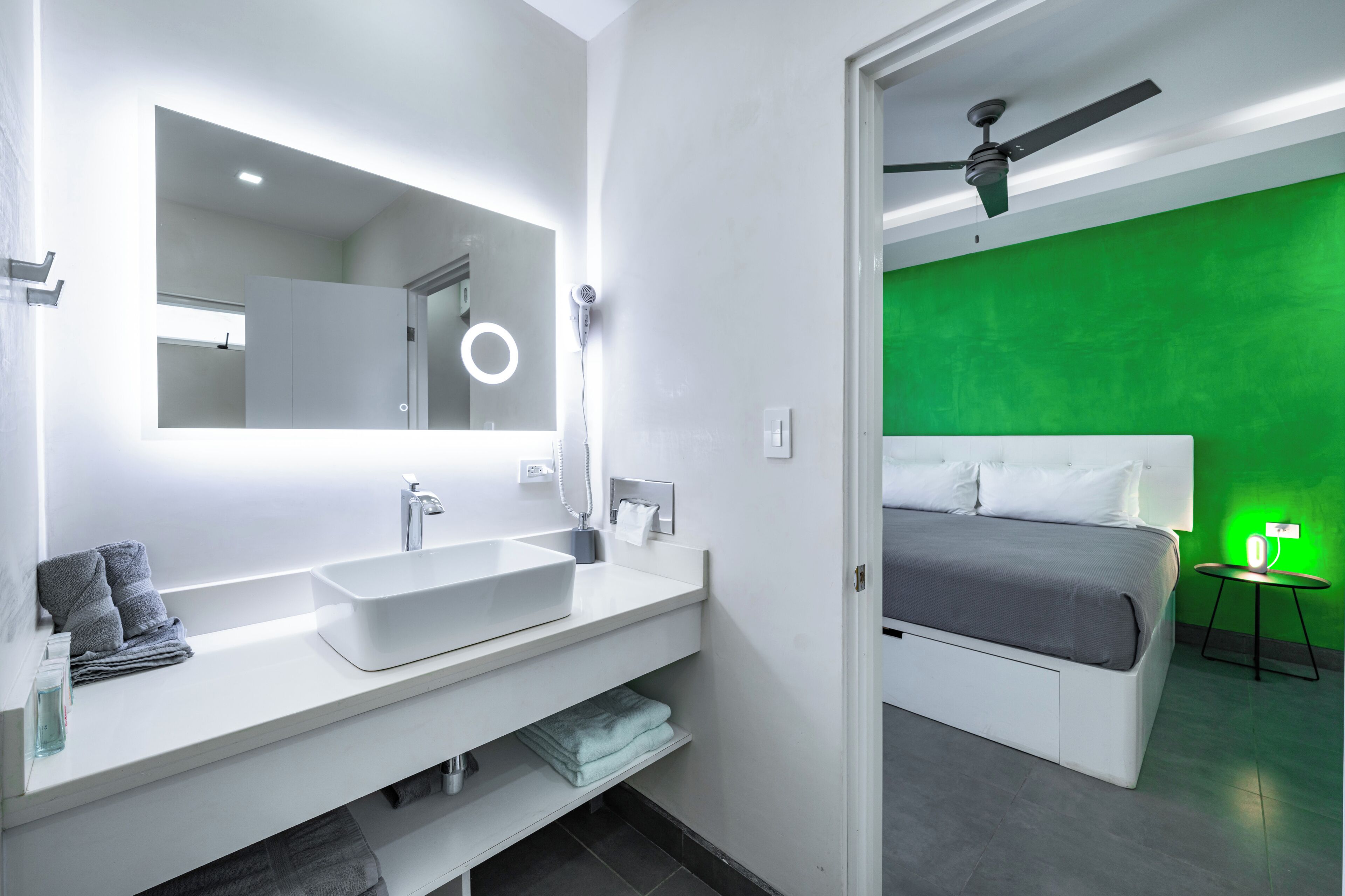 A modern bathroom with a large mirror, dual sinks, and a vanity.