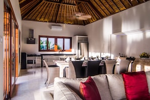 Relax in this spacious living area with a dining table, sofa, and neutral-toned couch.