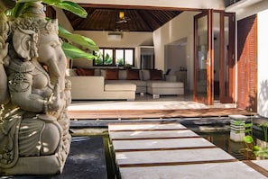 Relax in a serene living space with a comfortable sofa set and a unique elephant statue.