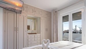 A bedroom with a bed, a wardrobe, a vanity with a mirror, and a window with blinds. - 2 Beautiful Beach Front Villa in Mijas Playa Club (La Cala de Mijas)