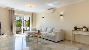 A modern living room with a sofa, coffee table, and a dining table set with food and drinks. - 2 Beautiful Beach Front Villa in Mijas Playa Club (La Cala de Mijas)