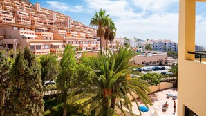 Un quartier résidentiel situé sur la côte, avec des immeubles à plusieurs étages, un parking et un ciel dégagé.