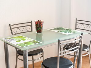 A dining table with a glass top and four metal chairs. A decorative vase with colorful items is placed on the table. - 651 Bright establishment, heated pool and Wi Fi (Los Cristianos)