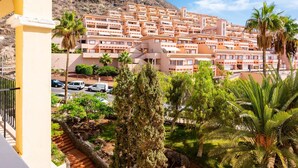 Un quartier résidentiel situé sur la côte, avec des immeubles à plusieurs étages, un ciel dégagé et des palmiers.