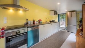 A compact kitchen with a dishwasher, oven, and a microwave.