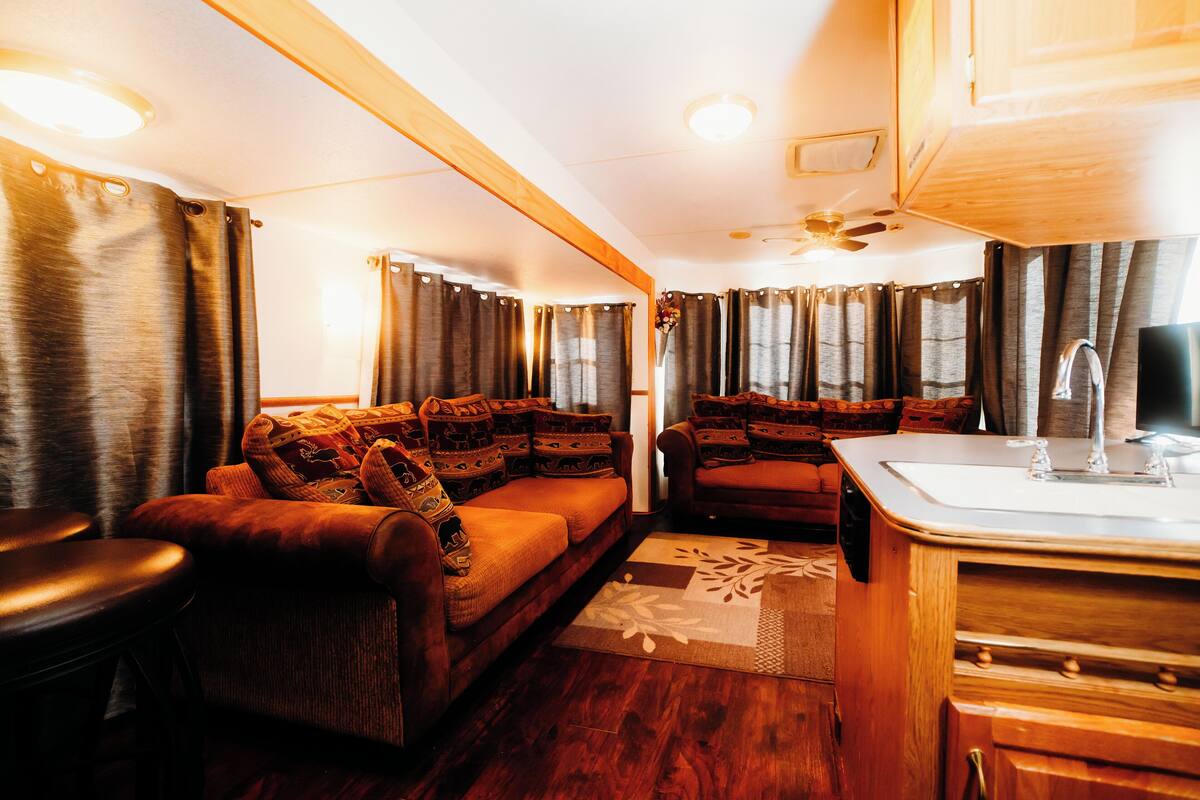 A compact living space with a sofa, a small table, and a kitchenette area.