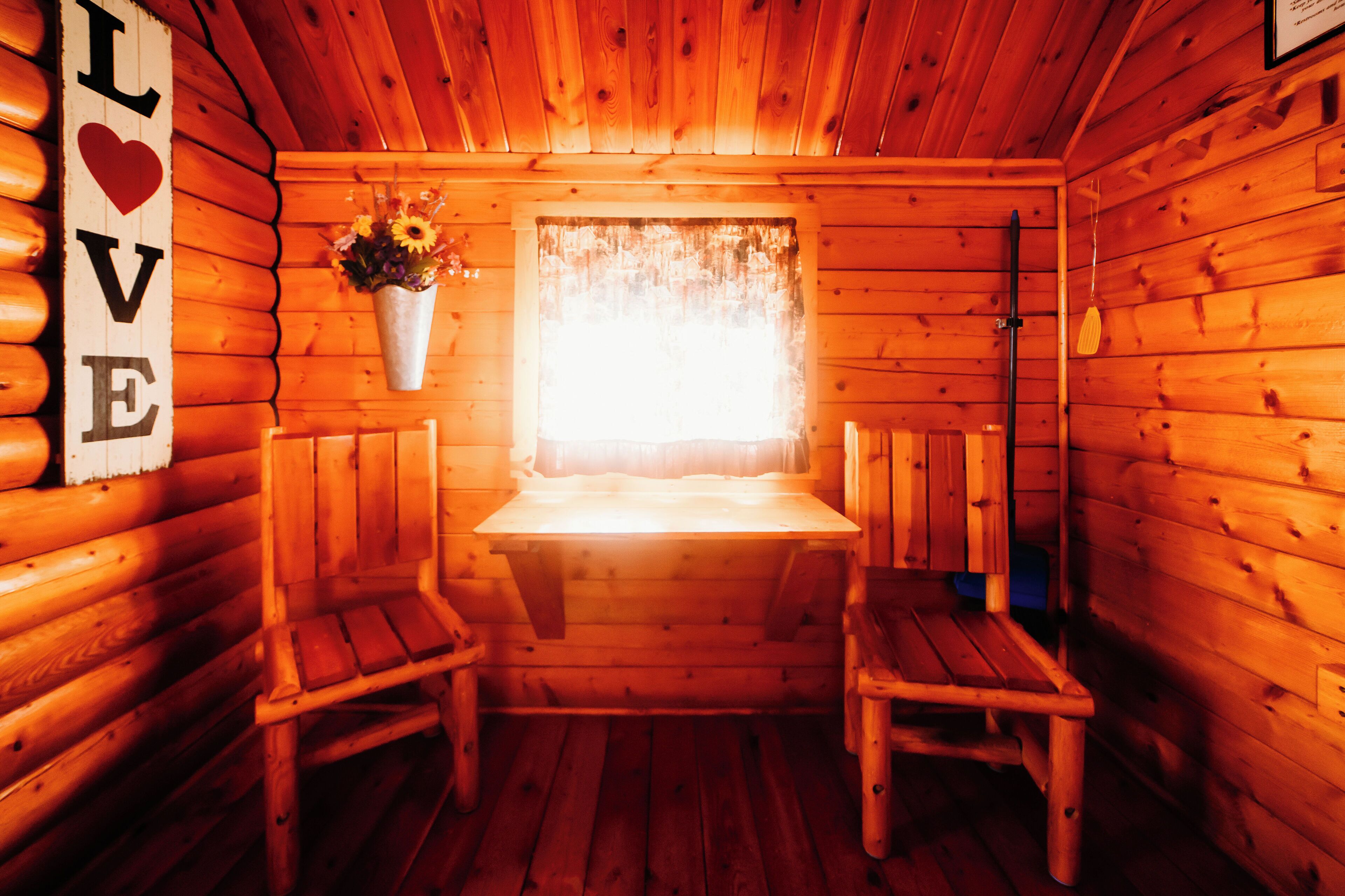 Una cabaña acogedora con paredes de madera y un banco en el centro.