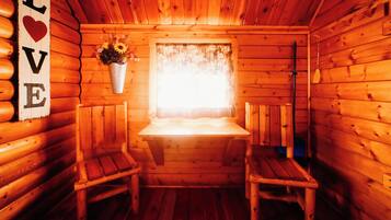 Una cabaña acogedora con paredes de madera y un banco en el centro.