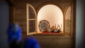 Een houten interieur met een rond raam, een decoratief bord en gewei.