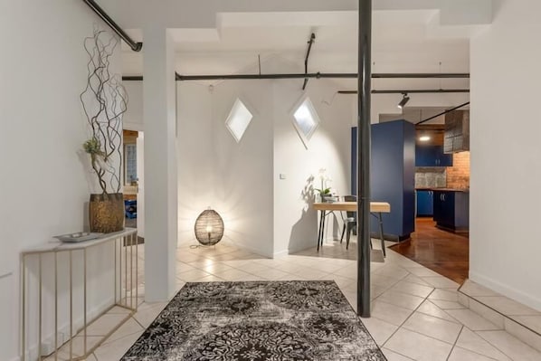 Experience the simplicity of a modern space with a patterned rug, contemporary dining area, and abstract art piece.