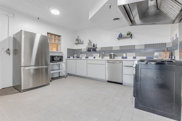 Enjoy cooking in this well-equipped kitchen with a refrigerator, dishwasher, and oven, plus ample storage and a window above the sink.