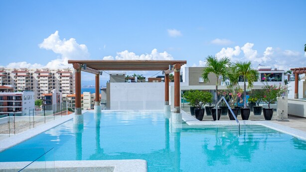 A rooftop swimming pool with a pergola, potted plants, and a view of the cityscape. - New renovated Penthouse in V399! 2BD Penthouse for rent in Old Town, Puerto vall (Puerto Vallarta)