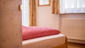 Una camera da letto con un letto, un termosifone e delle tende.